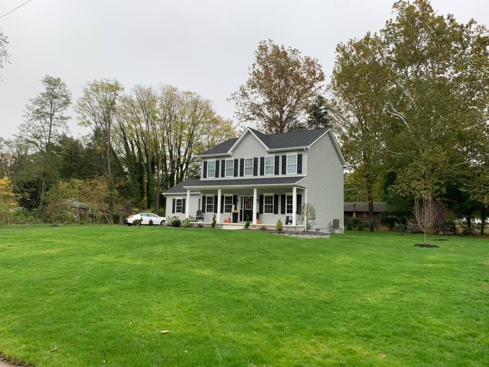 A large white house with a large lawn in front of it.