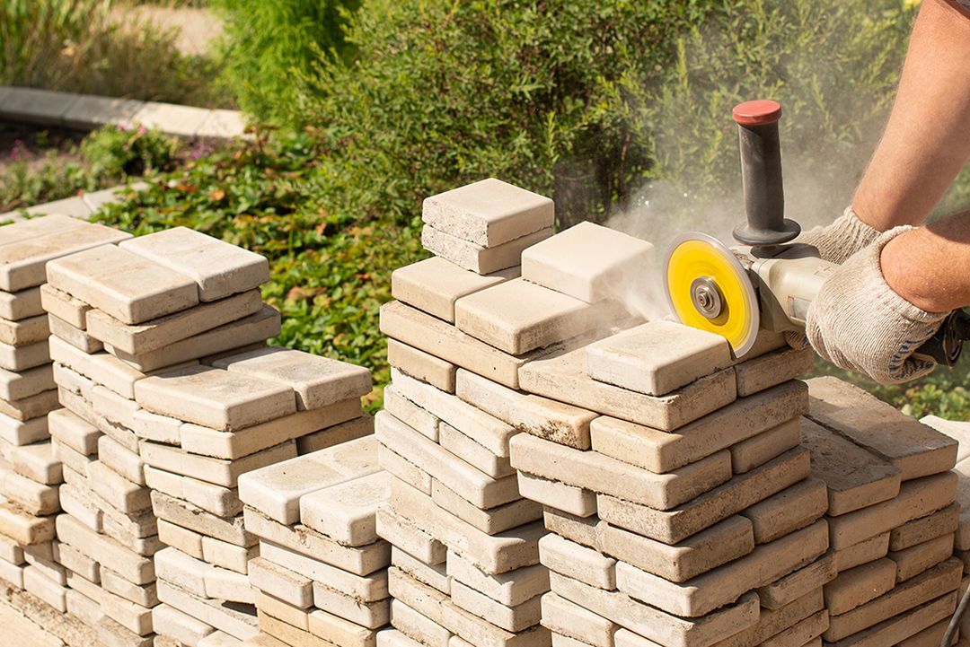 A person is cutting bricks with a grinder.