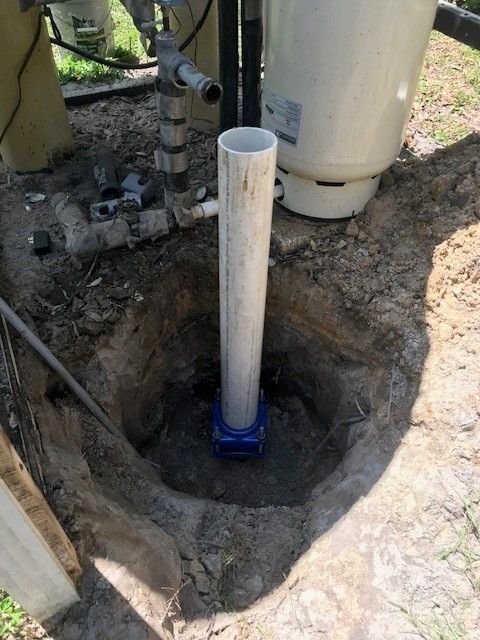 Person in blue shirt holding HVAC gauges with red, yellow, and black hoses.