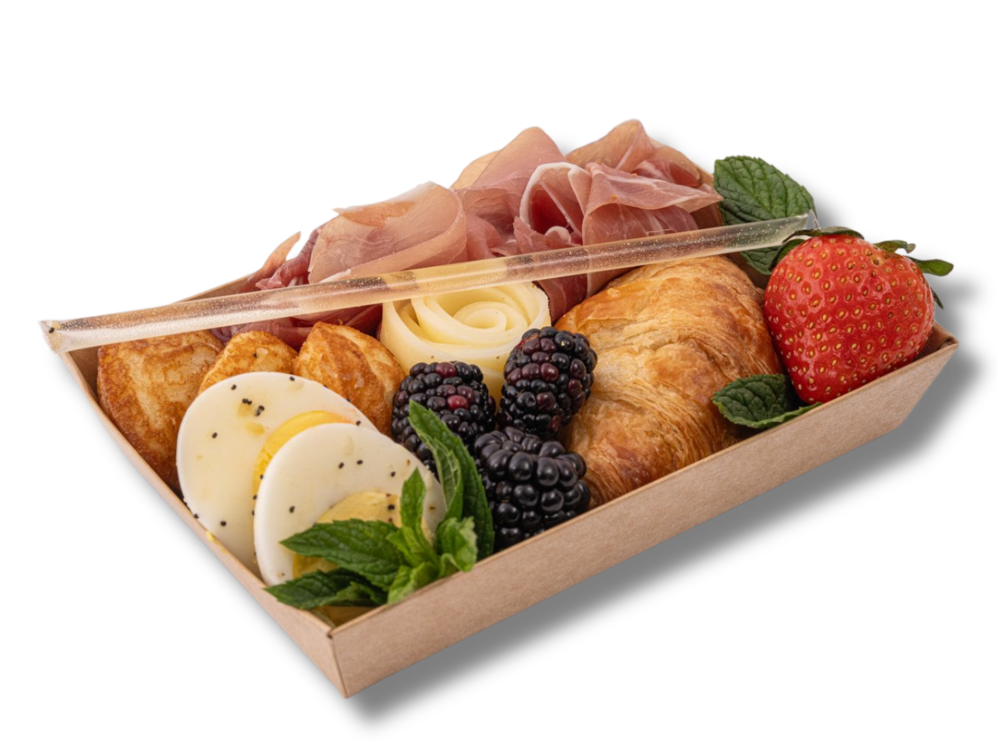 A wooden tray filled with food including eggs croissants berries and ham.