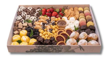 A box filled with a variety of desserts and fruit.