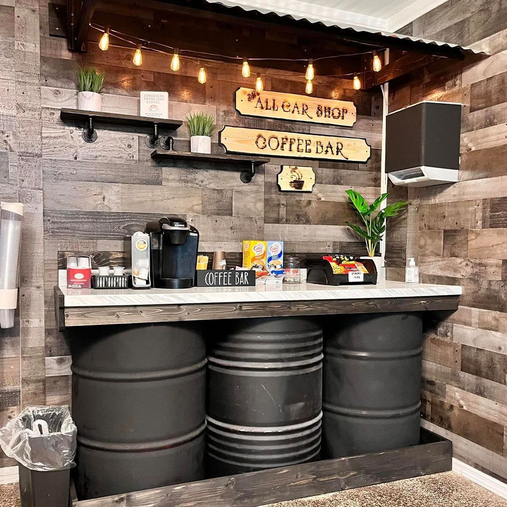 A coffee bar made out of barrels in a room with wooden walls.