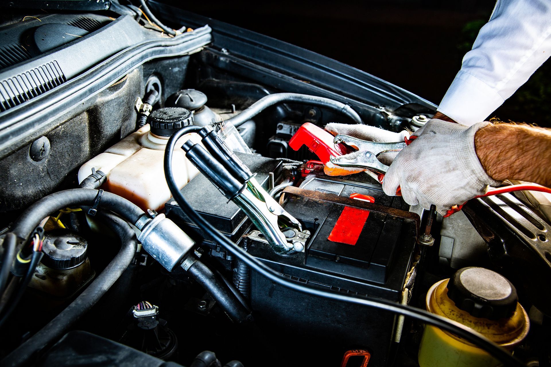 A person is charging a car battery with a jump starter.