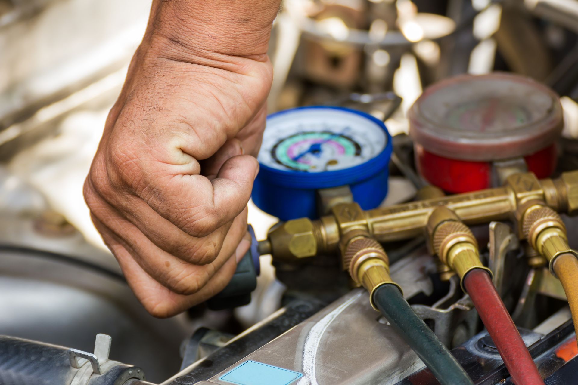 A man is recharging a cars air conditioning