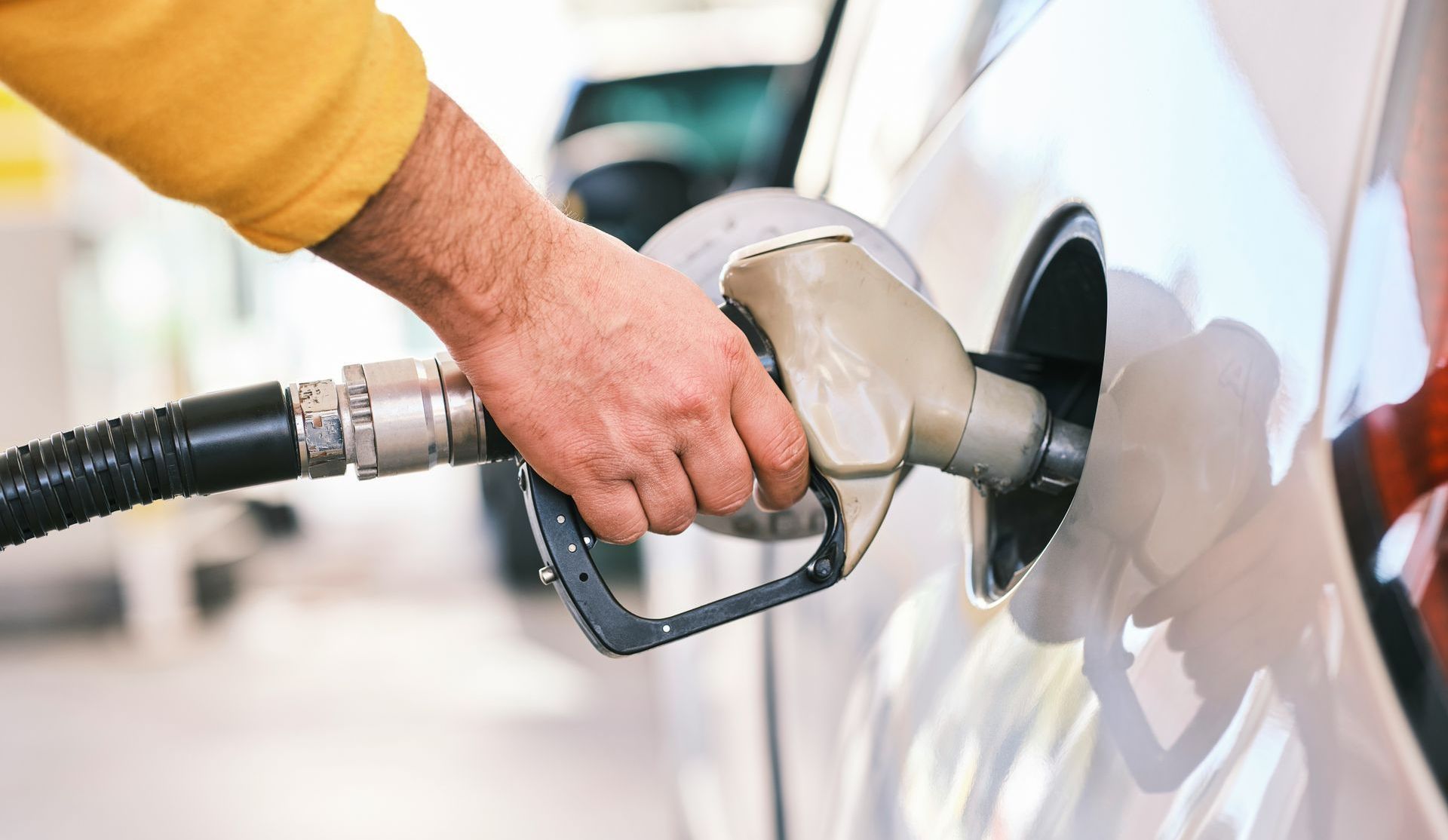 A person is pumping gas into a car at a gas station.