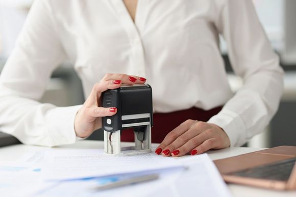 Businesswoman Puts Stamp on Documents — Savannah, GA — Discount Check Casher