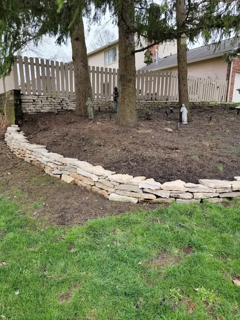 There is a stone wall in the middle of the yard.