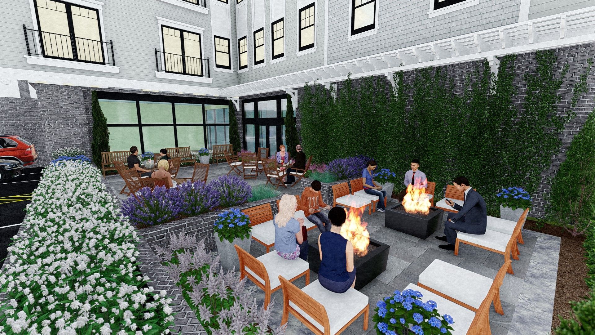 Outdoor patio gathering with people around a fire pit, plants, and building.