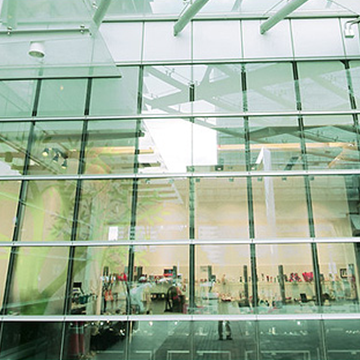 Mechanic's hands testing a car's engine with a multimeter; battery, hoses, and tubes visible.