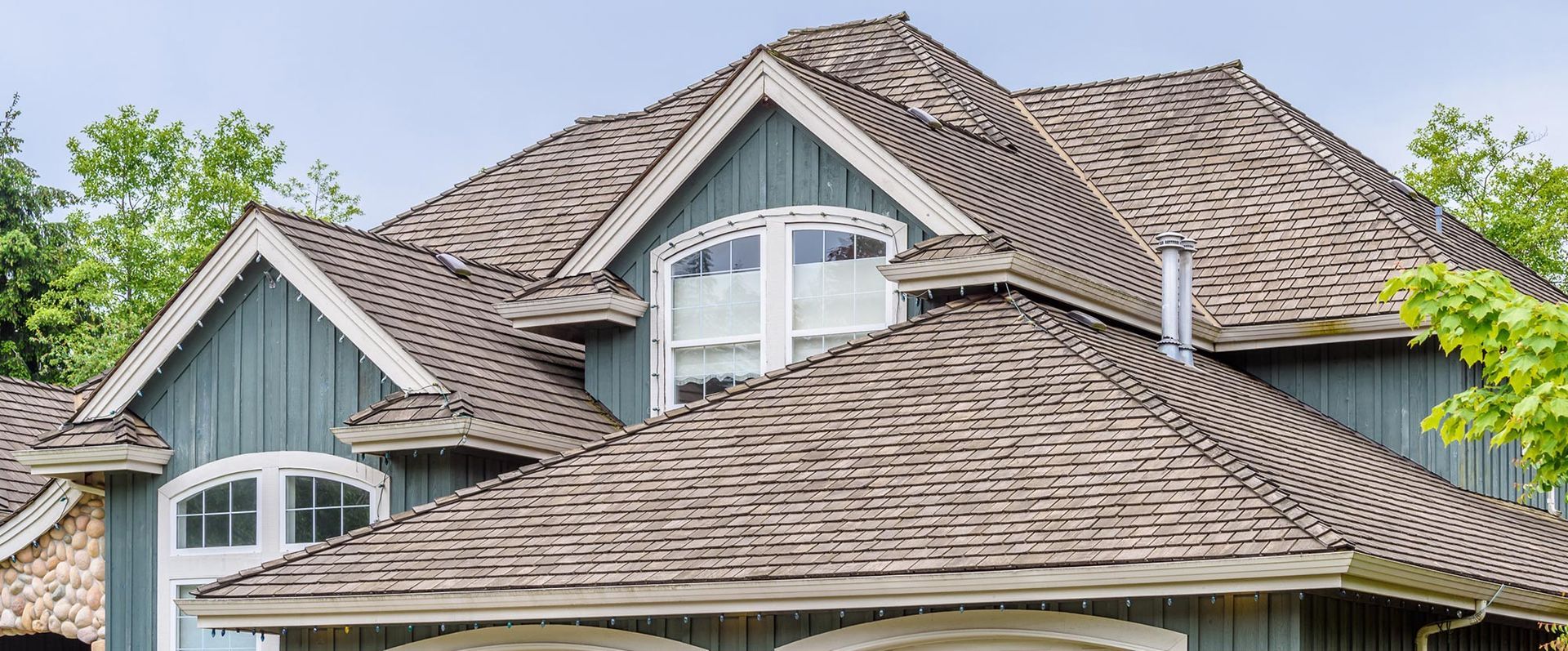 House exterior with blue siding and brown shingle roof.