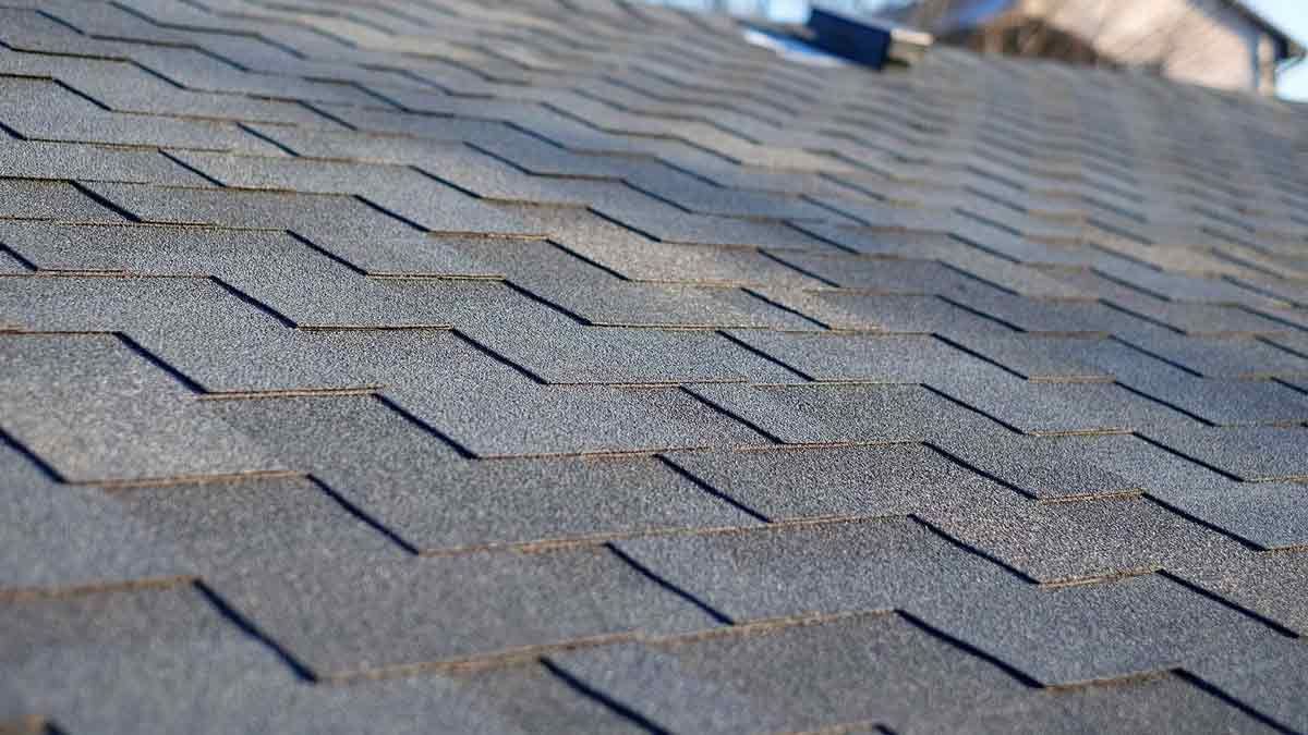 Close-up of a gray asphalt shingle roof, showing the textured surface and a subtle, consistent pattern.
