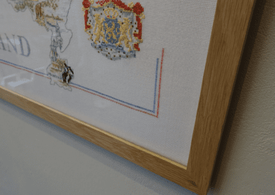A picture in a wooden frame is hanging on a wall. Fulham Framing | Bespoke Picture Framing