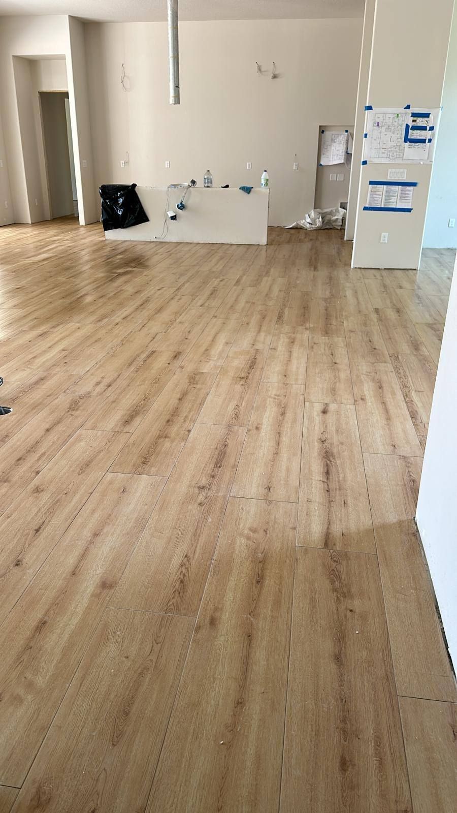 A large empty room with a wooden floor and white walls.