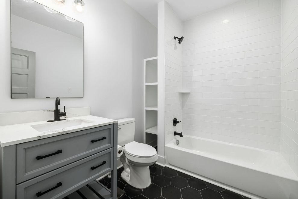 A bathroom with a toilet , sink , and bathtub.