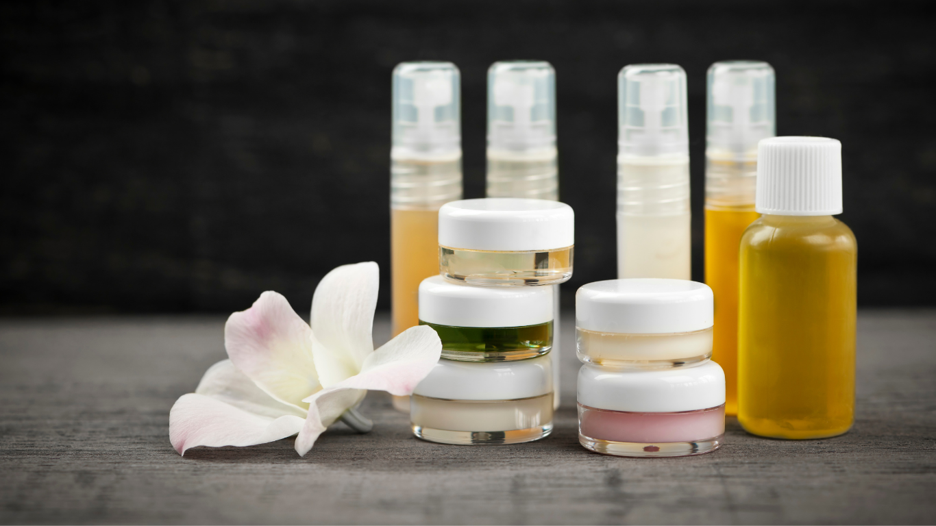 there are many different types of cosmetics and a flower on the table .