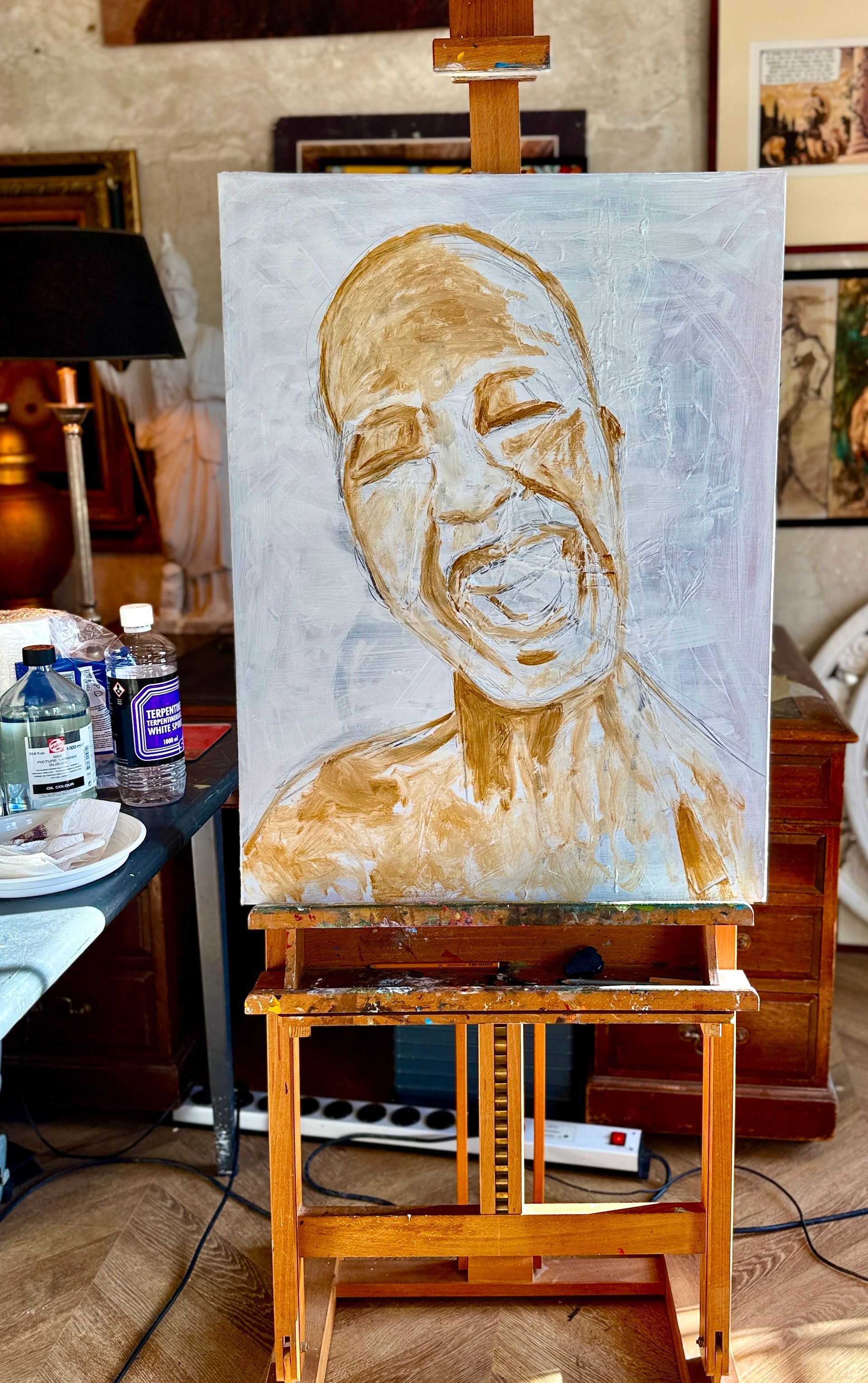 Portretschilderij op een ezel in een kunstenaarsatelier, met een lachend gezicht in warme goud- en beigetinten.
