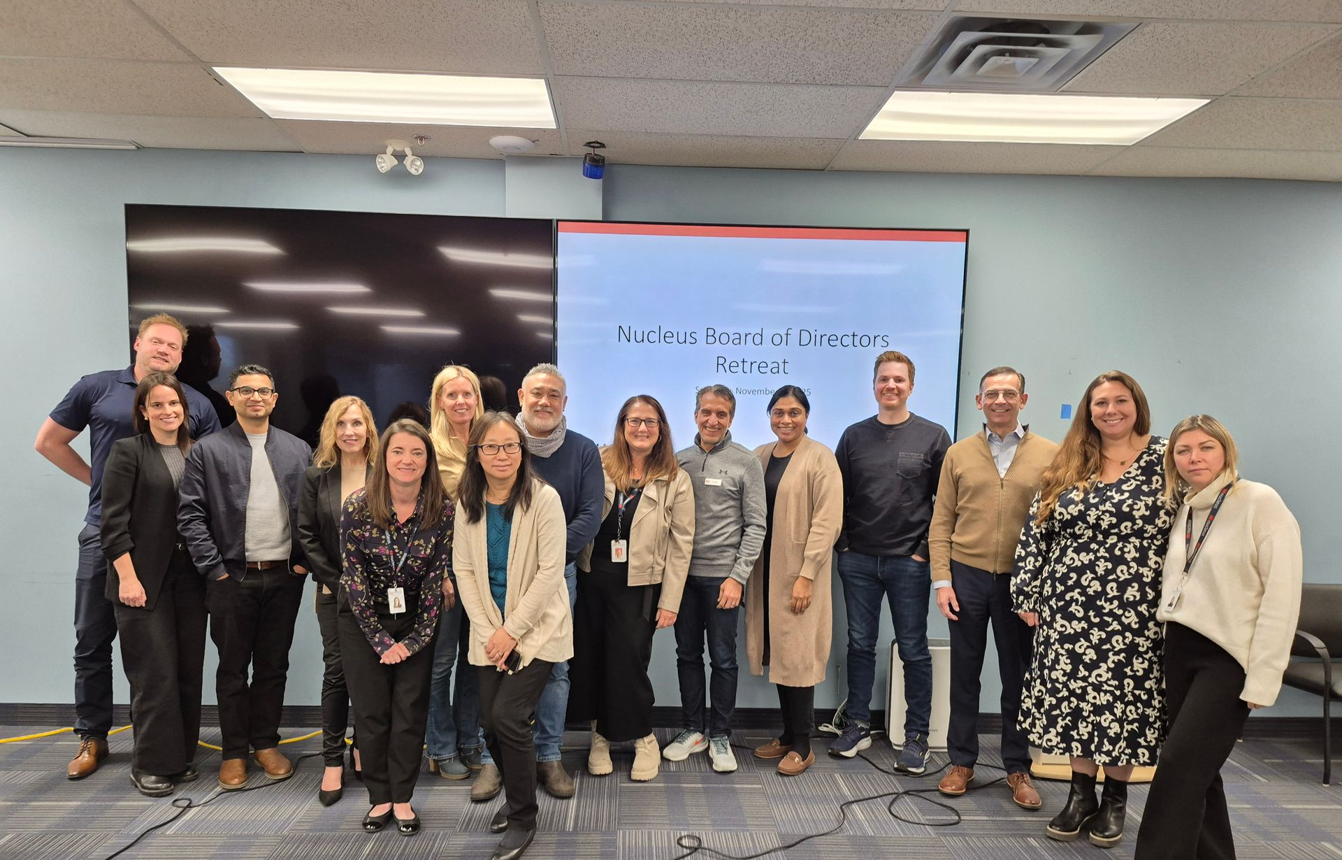 A group of people are posing for a picture in front of a building.