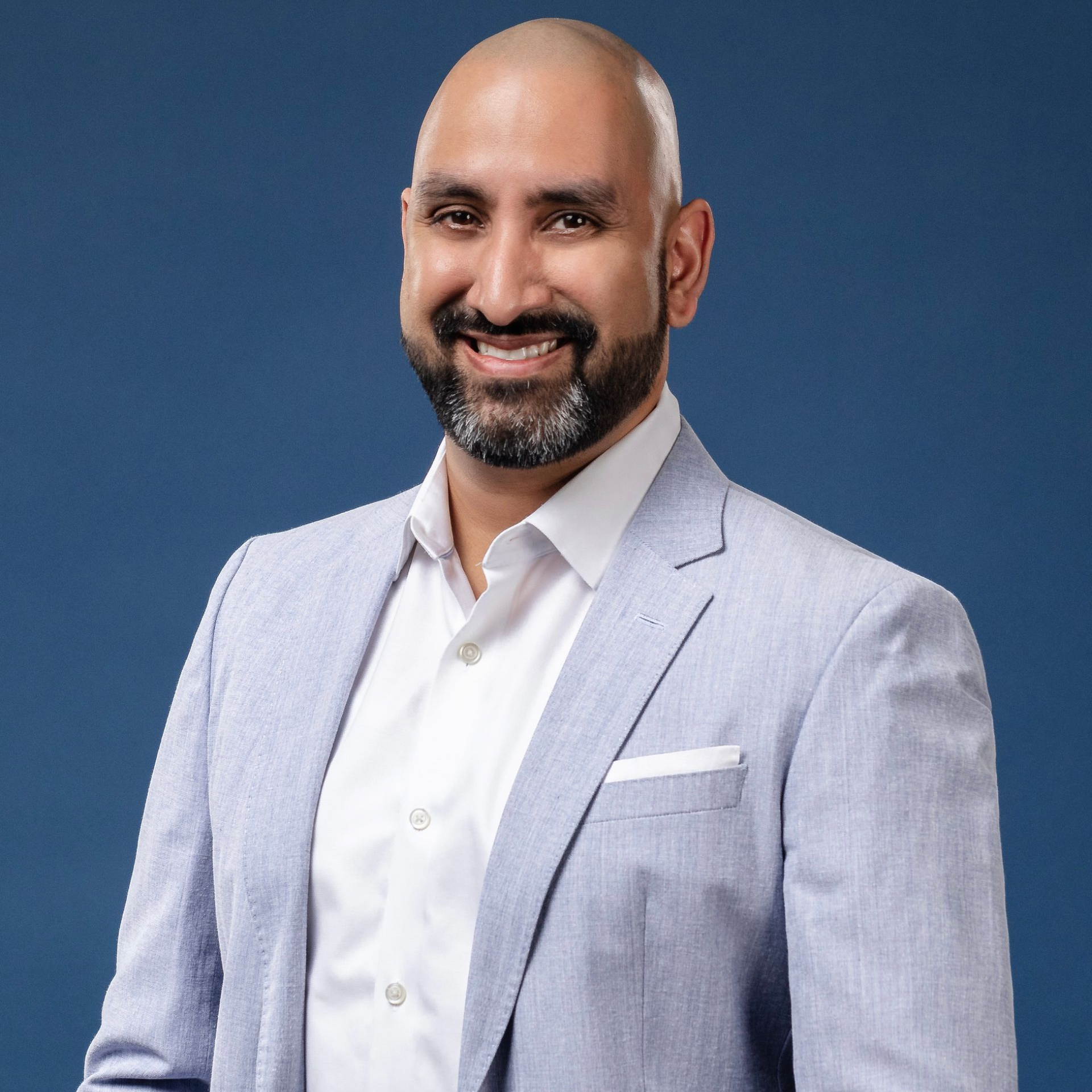 A man in a suit and tie is smiling for the camera.