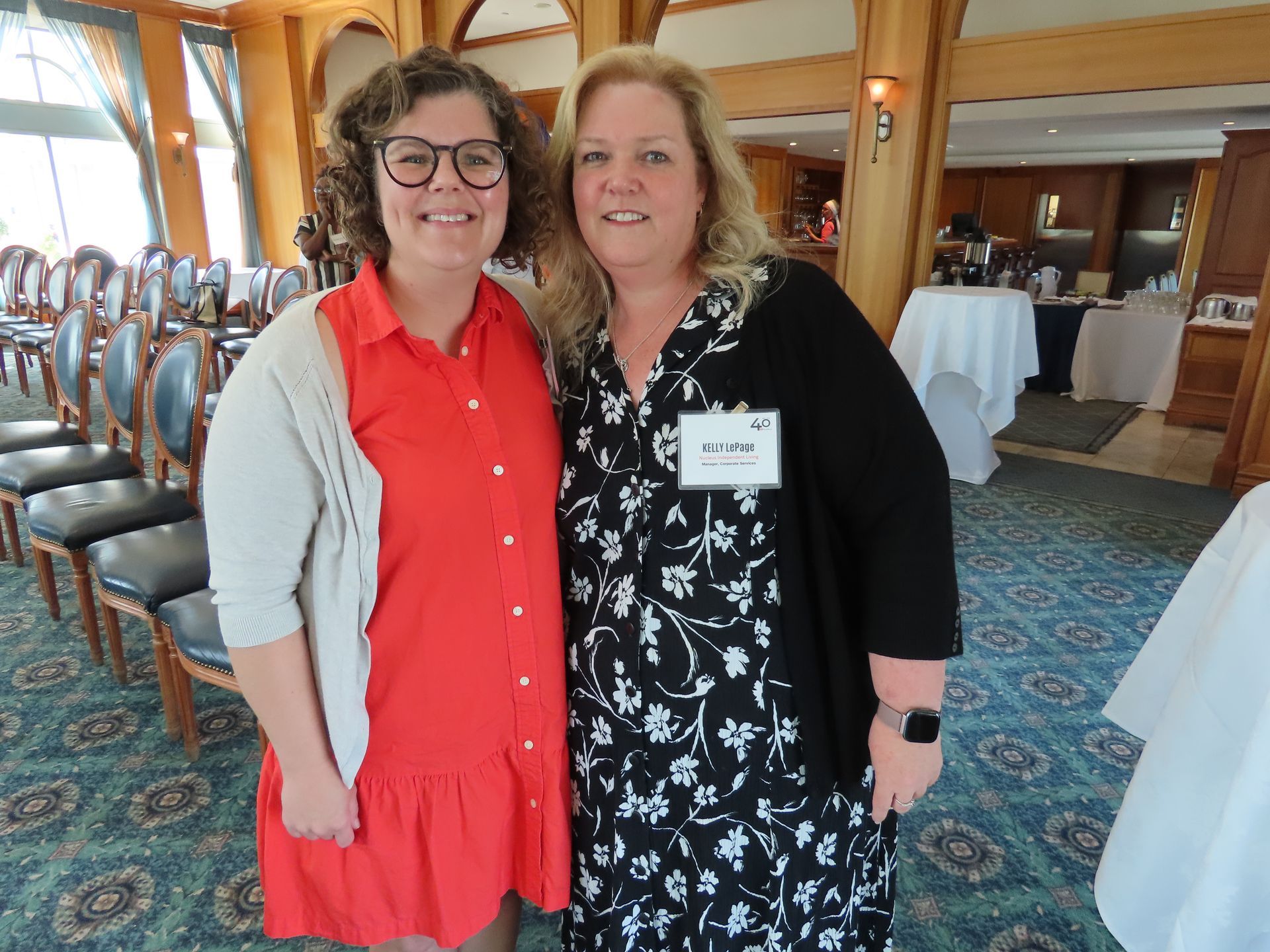Two women are posing for a picture together in a room.