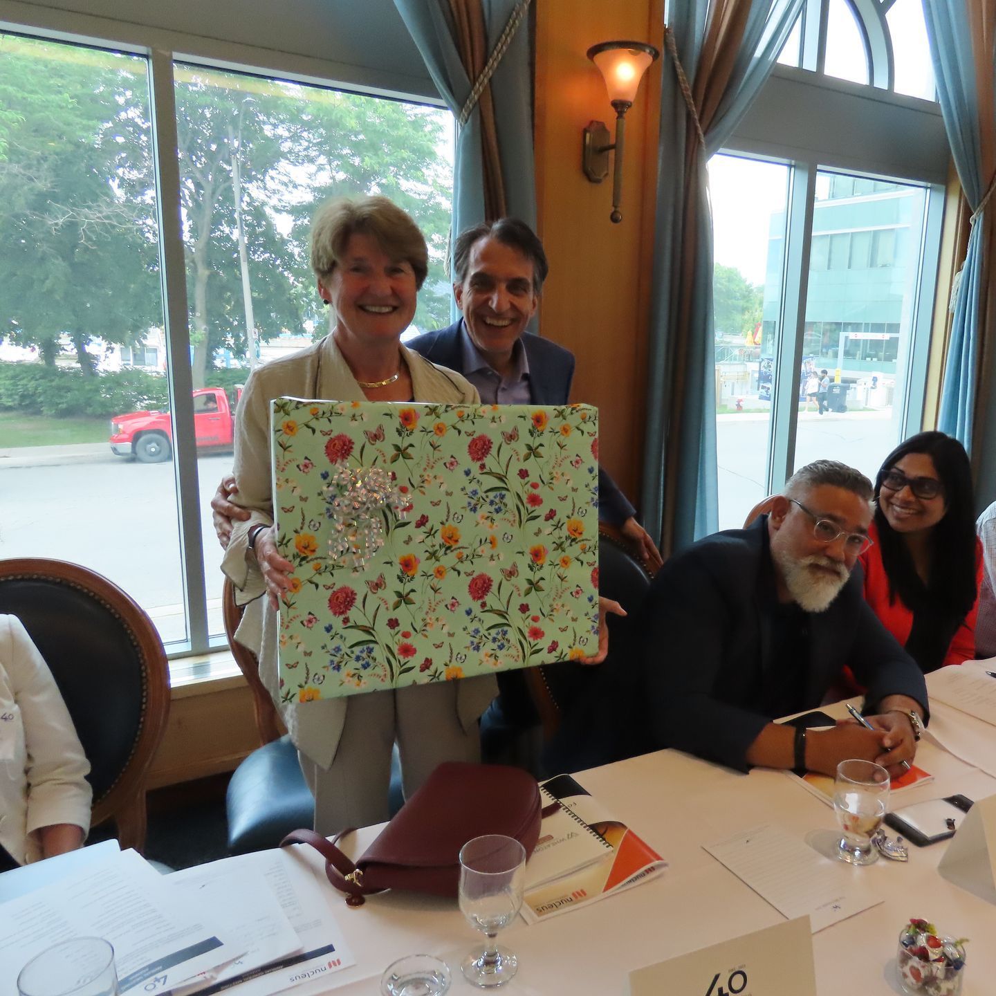 A group of people sitting at a table with a sign that says 60