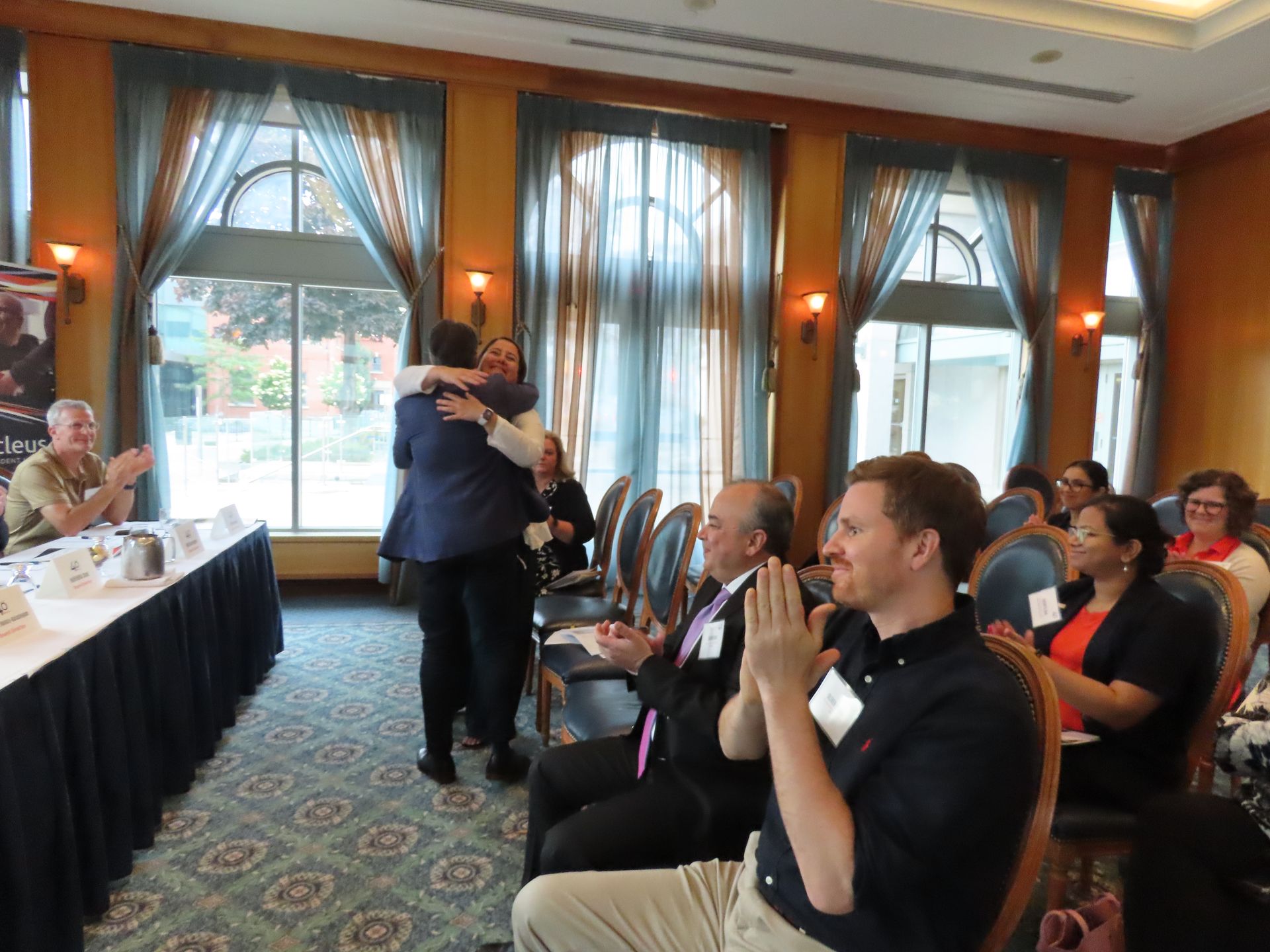 A group of people are sitting in a room and applauding