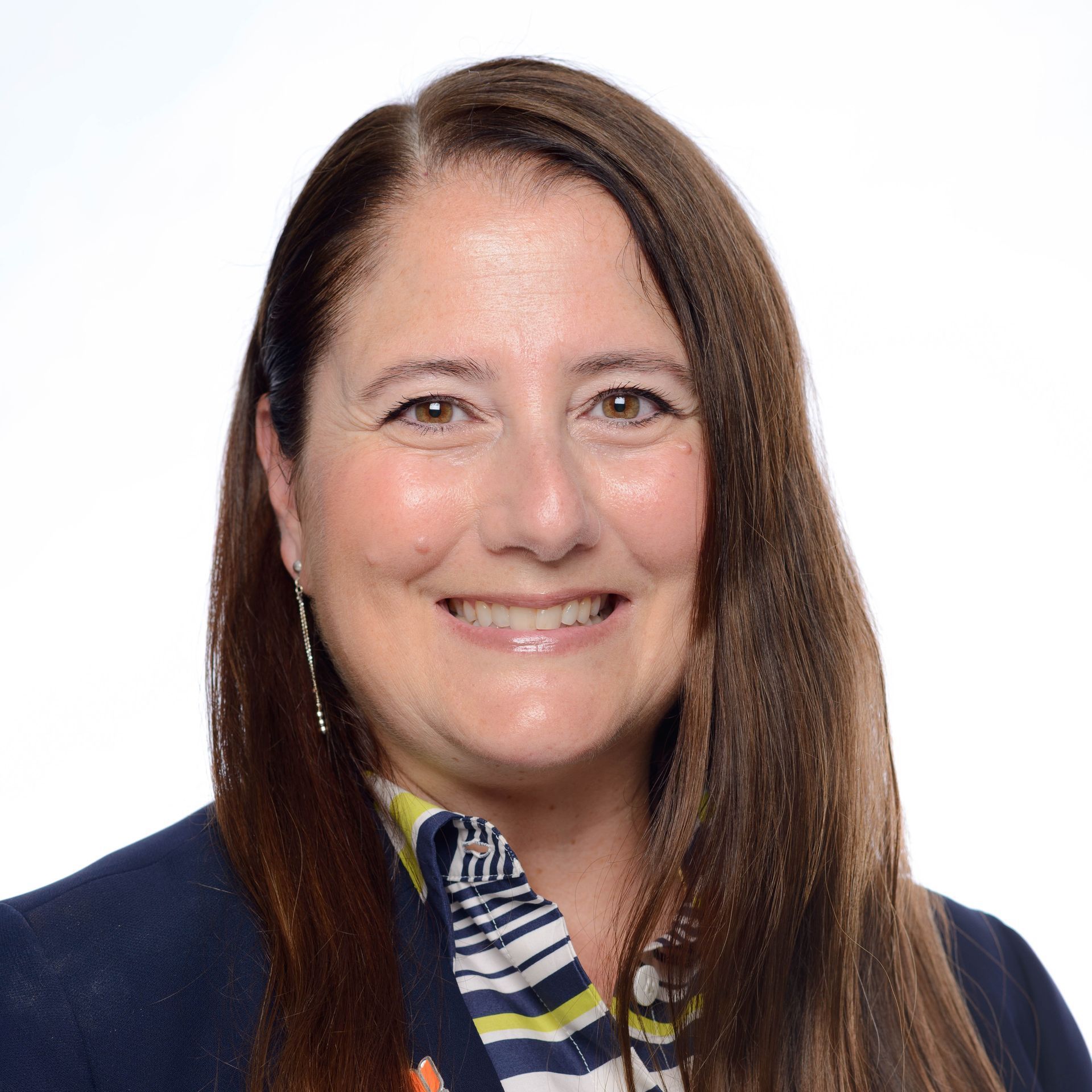 A woman wearing a necklace and a black top smiles for the camera