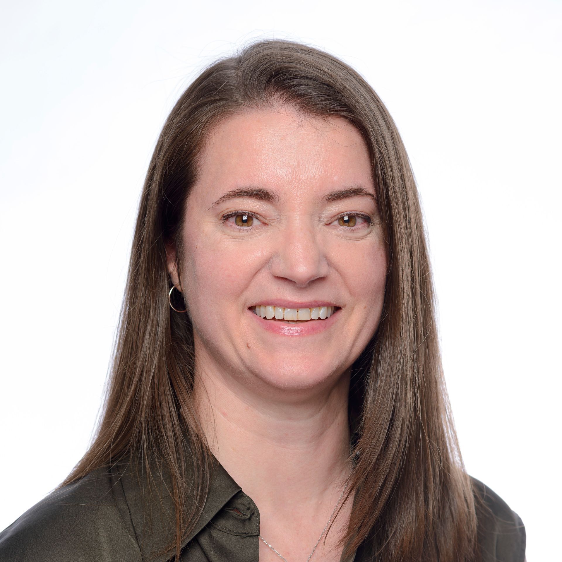 A woman in a brown shirt is smiling for the camera.