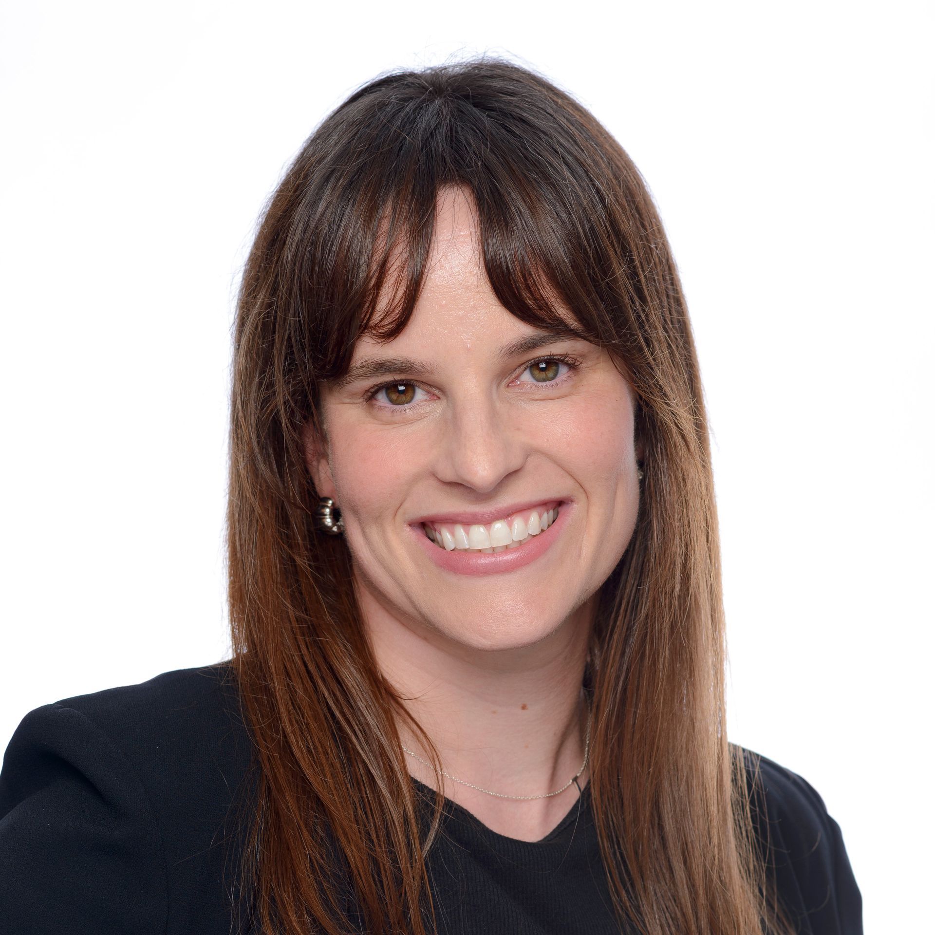 A woman with long brown hair is smiling and wearing a black shirt.