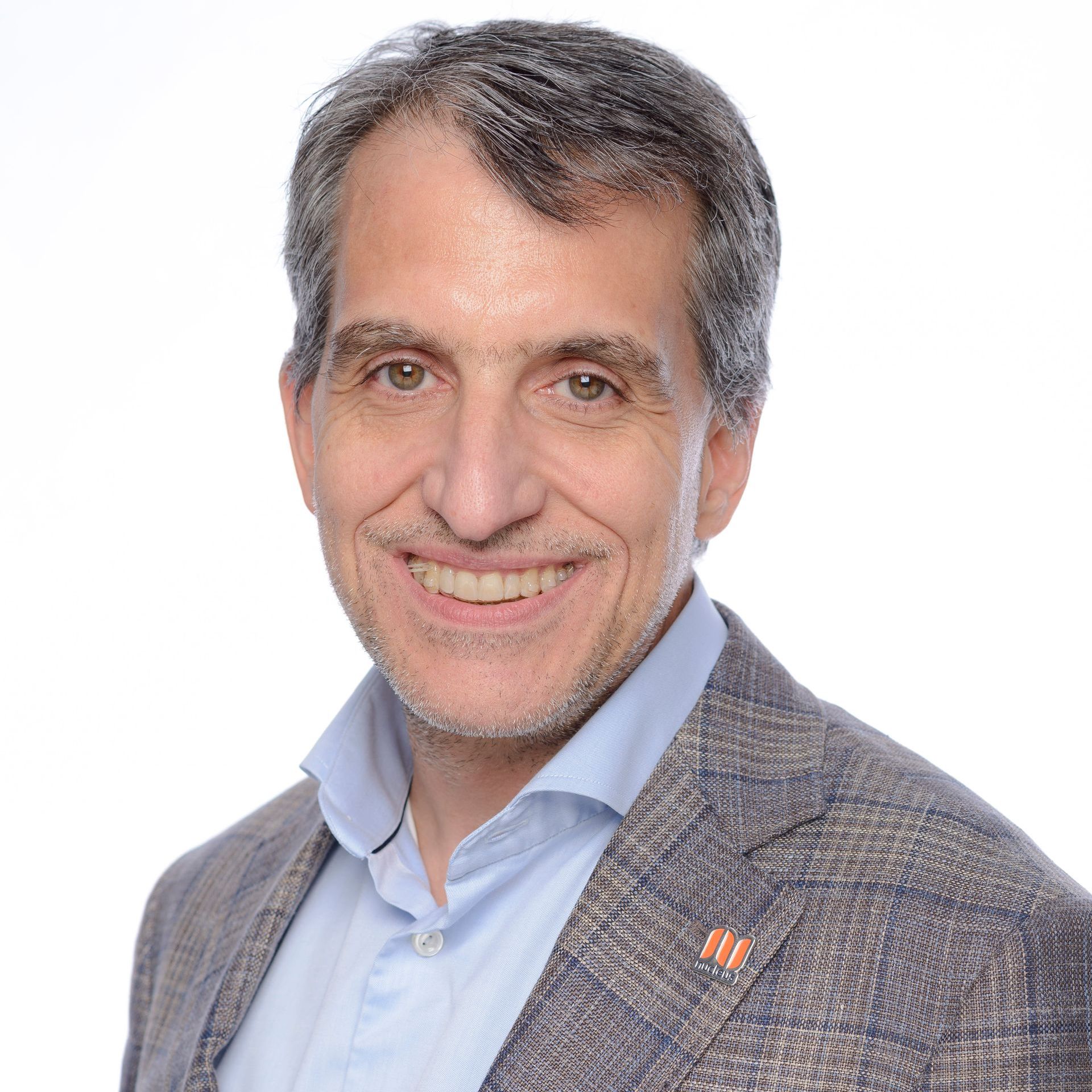 A man in a suit and tie is smiling for the camera.