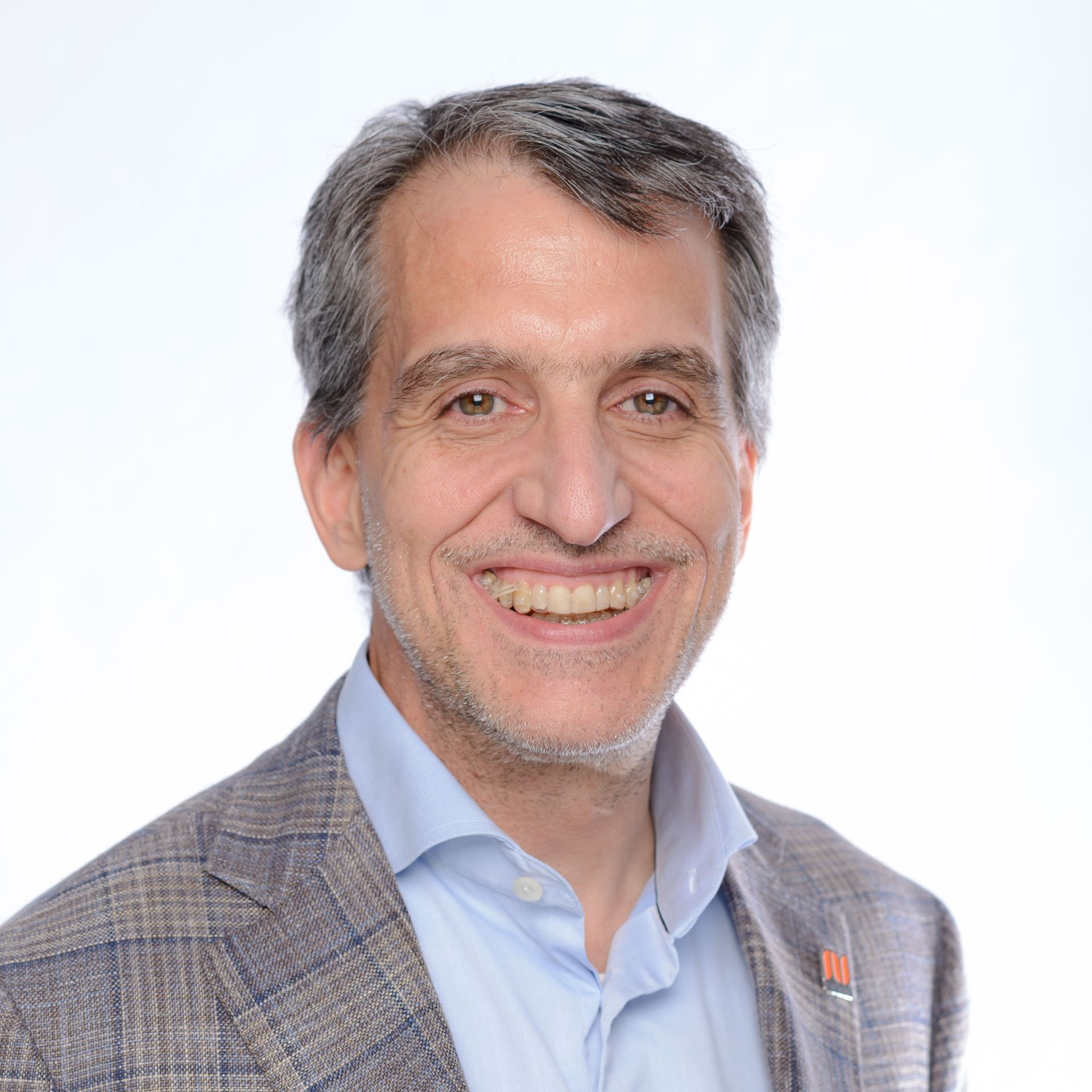 A man in a suit and tie is smiling for the camera.