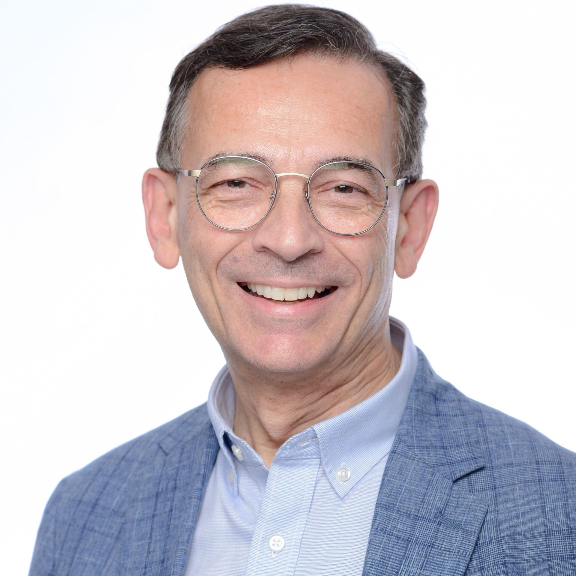 A man in a suit and tie is smiling for the camera.