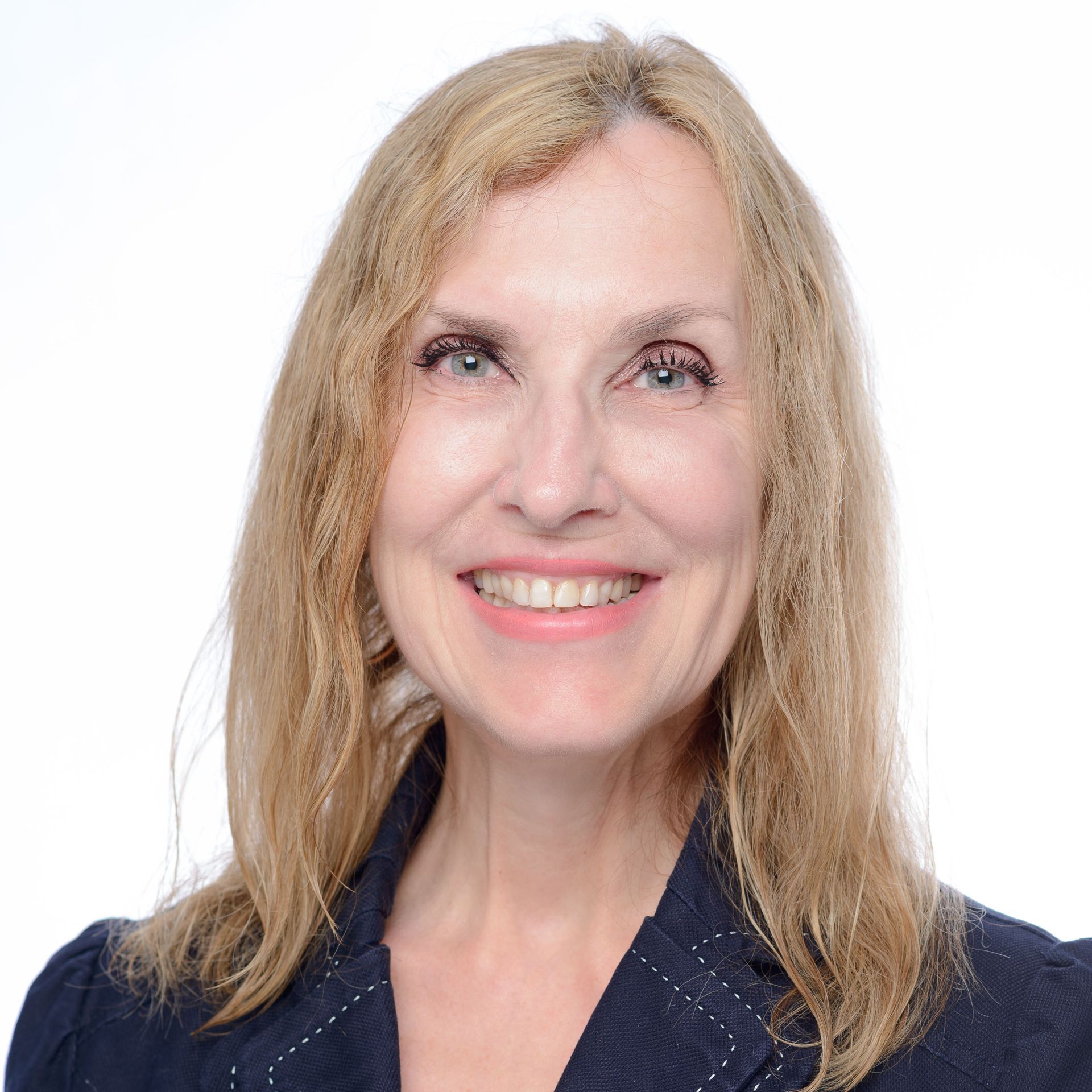 A woman in a black jacket is smiling for the camera.