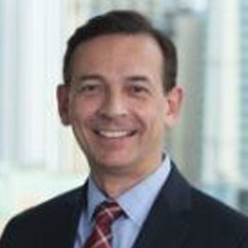 A man in a suit and tie is smiling for the camera.