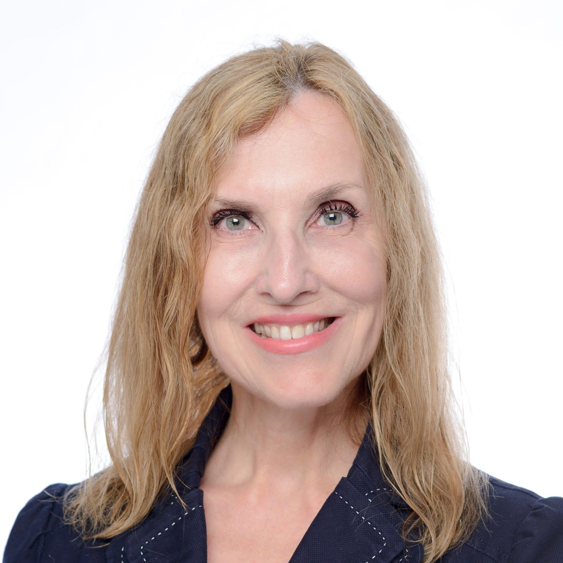 A woman in a black jacket is smiling for the camera.