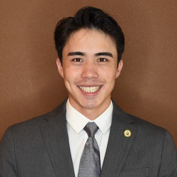 A man in a suit and tie is smiling for the camera