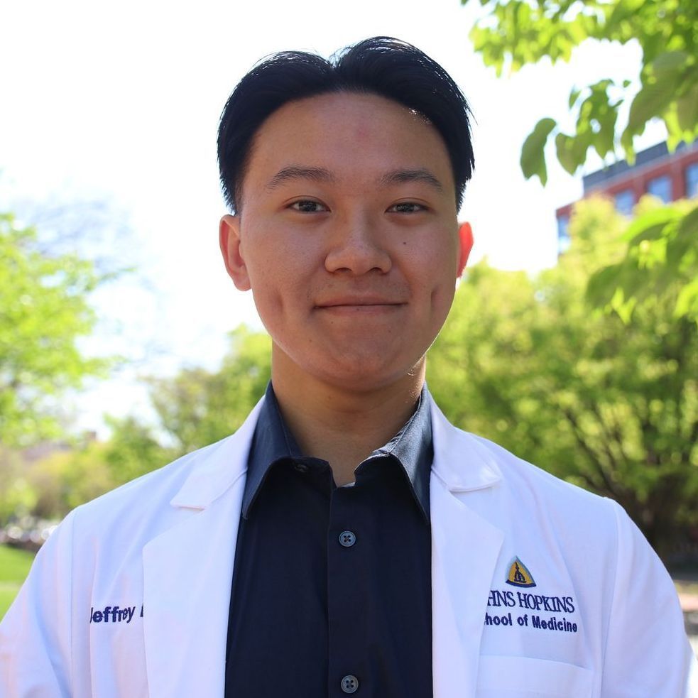 A man wearing a white lab coat that says heal of medicine