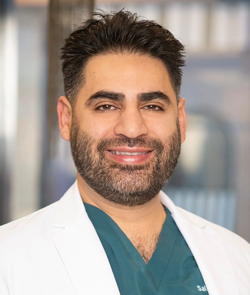 Doctor Hazany in green scrubs and a white coat