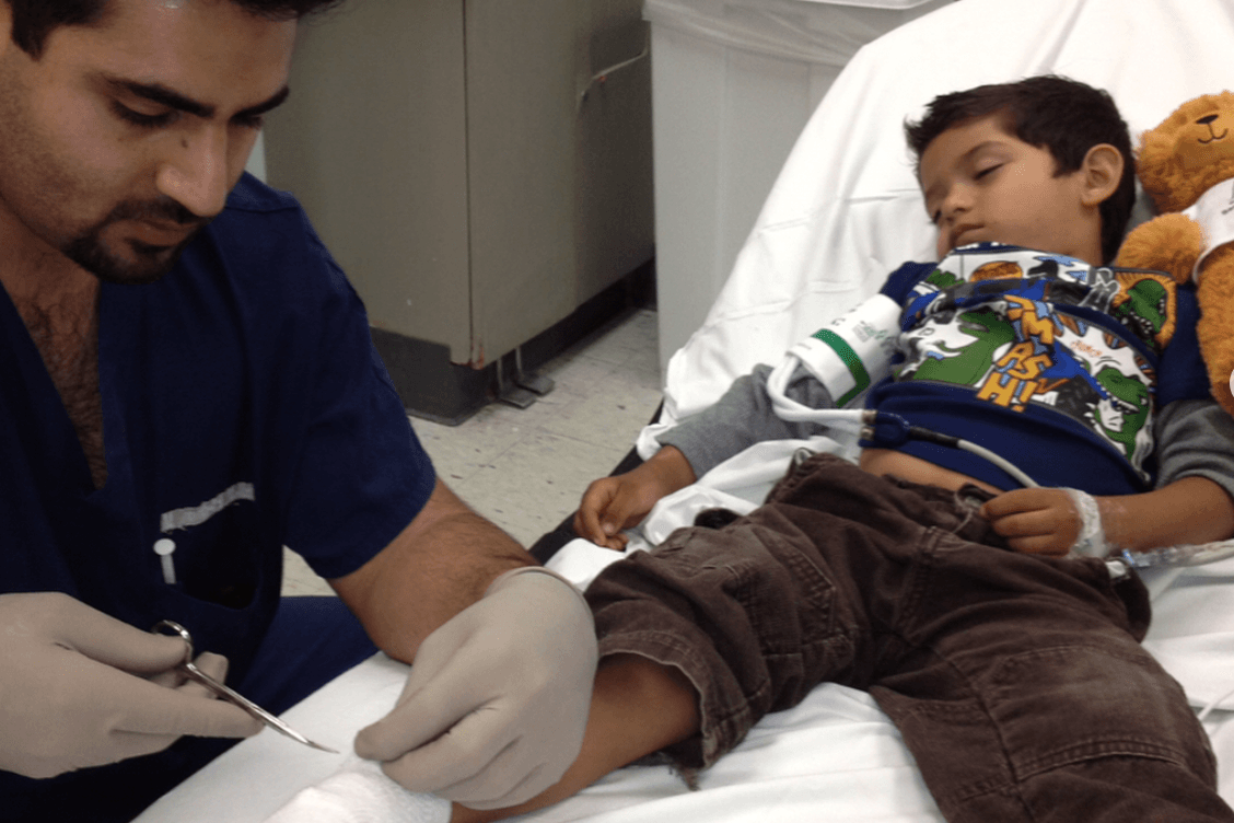 Dr. Hazany Providing Dermatology Care for a Young Child, Putting a Dressing on the Child's foot