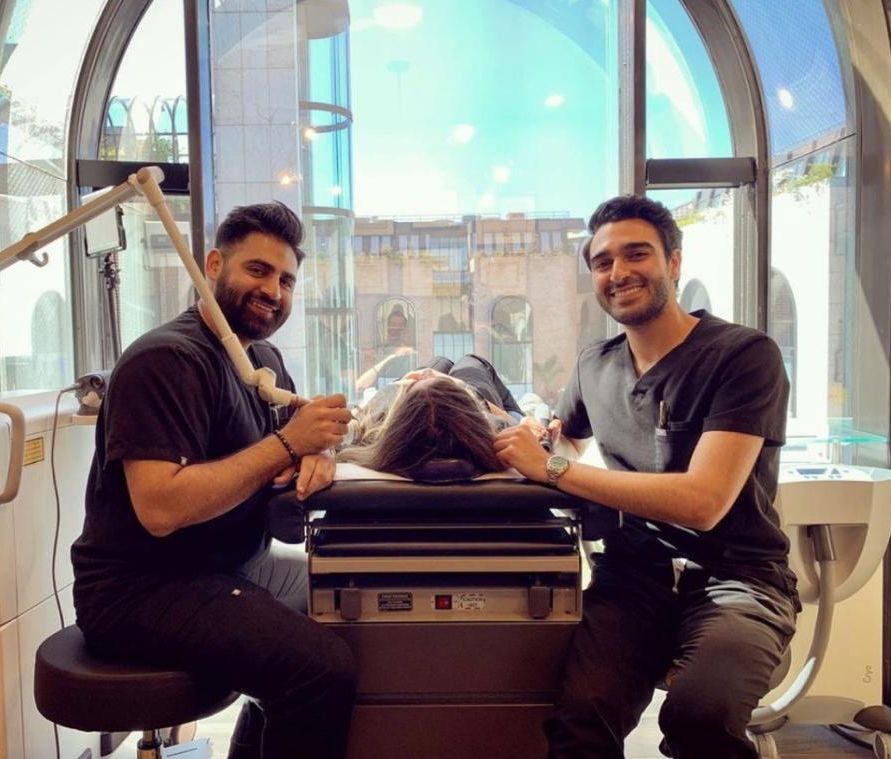 Two men are sitting next to each other in a dental office.