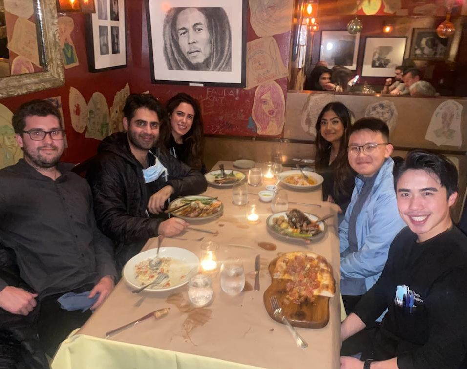 A group of people are sitting at a table with plates of food.