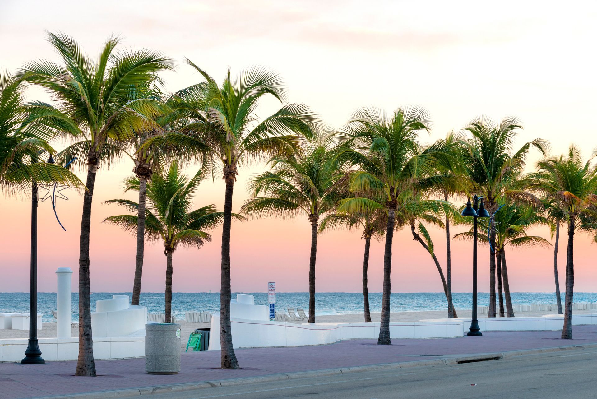 A large house with two garages and palm trees in front of it