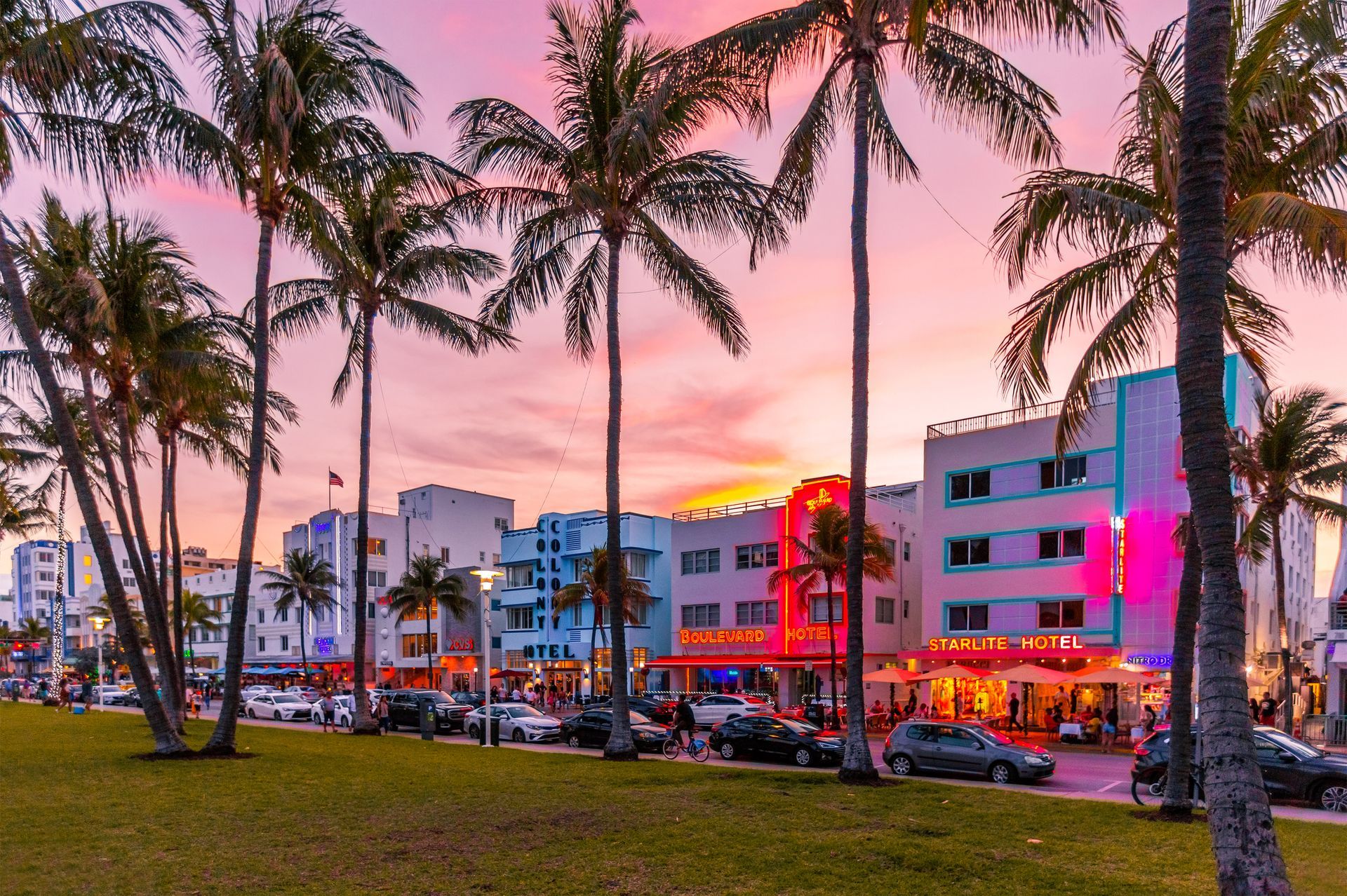 A row of mobile homes in a residential area with palm trees and a sidewalk.