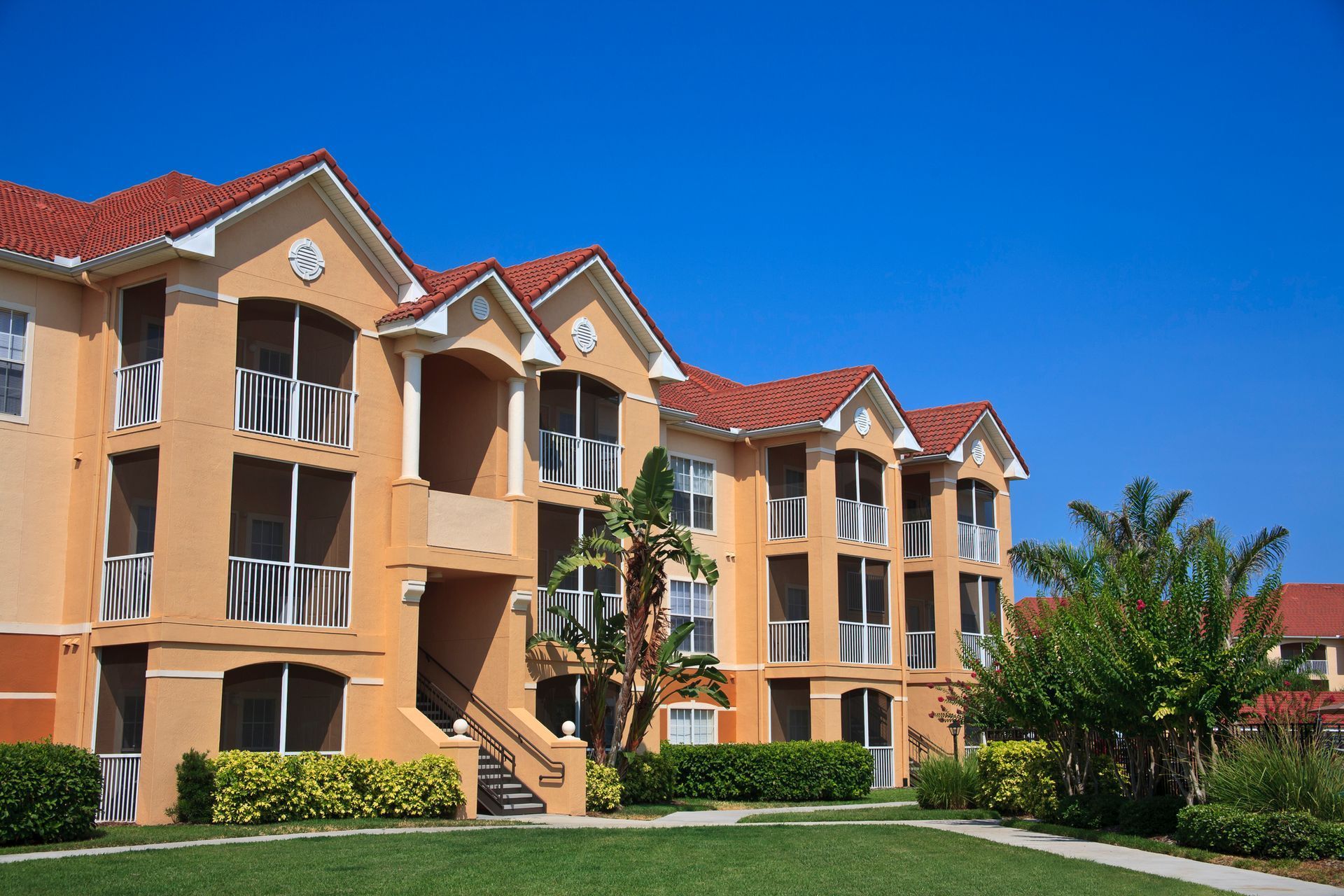 A large apartment building with a red tile roof