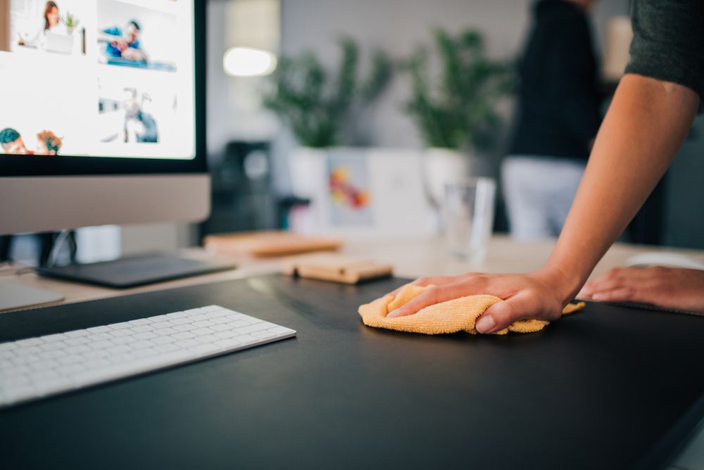 Person Cleaning Keyboard at a Desk — Serena's Local Cleaning Company In Toowoomba, QLD