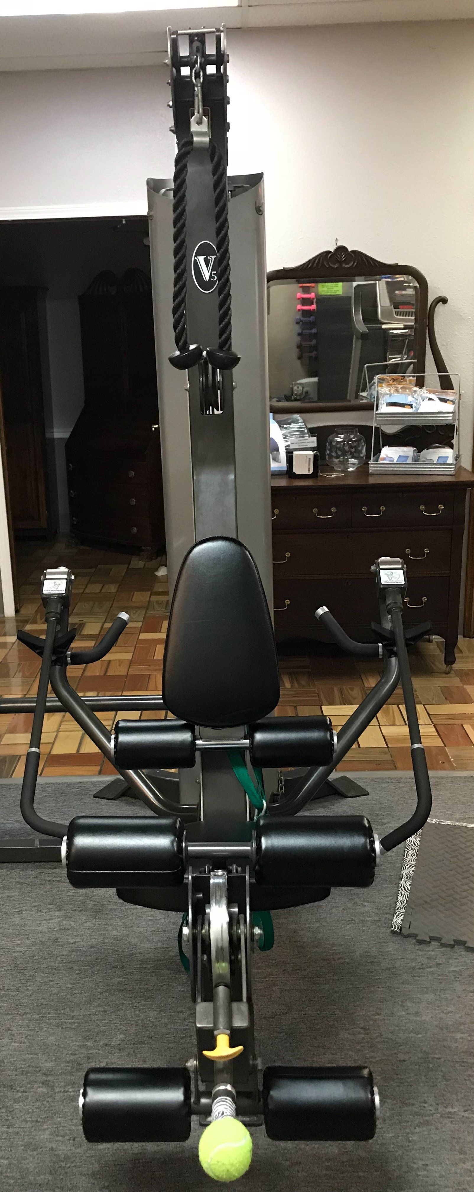 A gym machine is sitting on a carpet in a room.