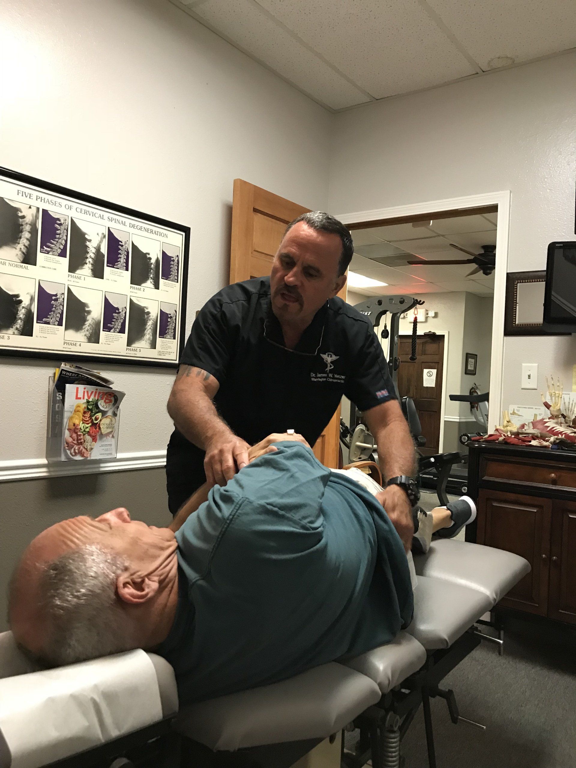 A man is laying on a table getting a massage from a doctor.