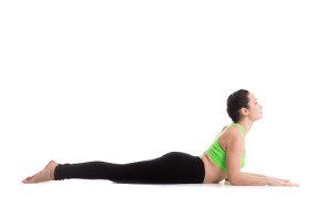 A woman is doing a yoga pose on a white background.