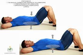 A man is laying on his stomach stretching his back.