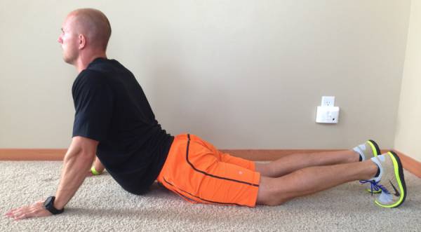 A man is doing a stretching exercise on the floor.
