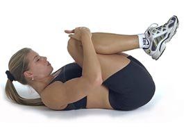 A woman is laying on her stomach with her legs crossed.